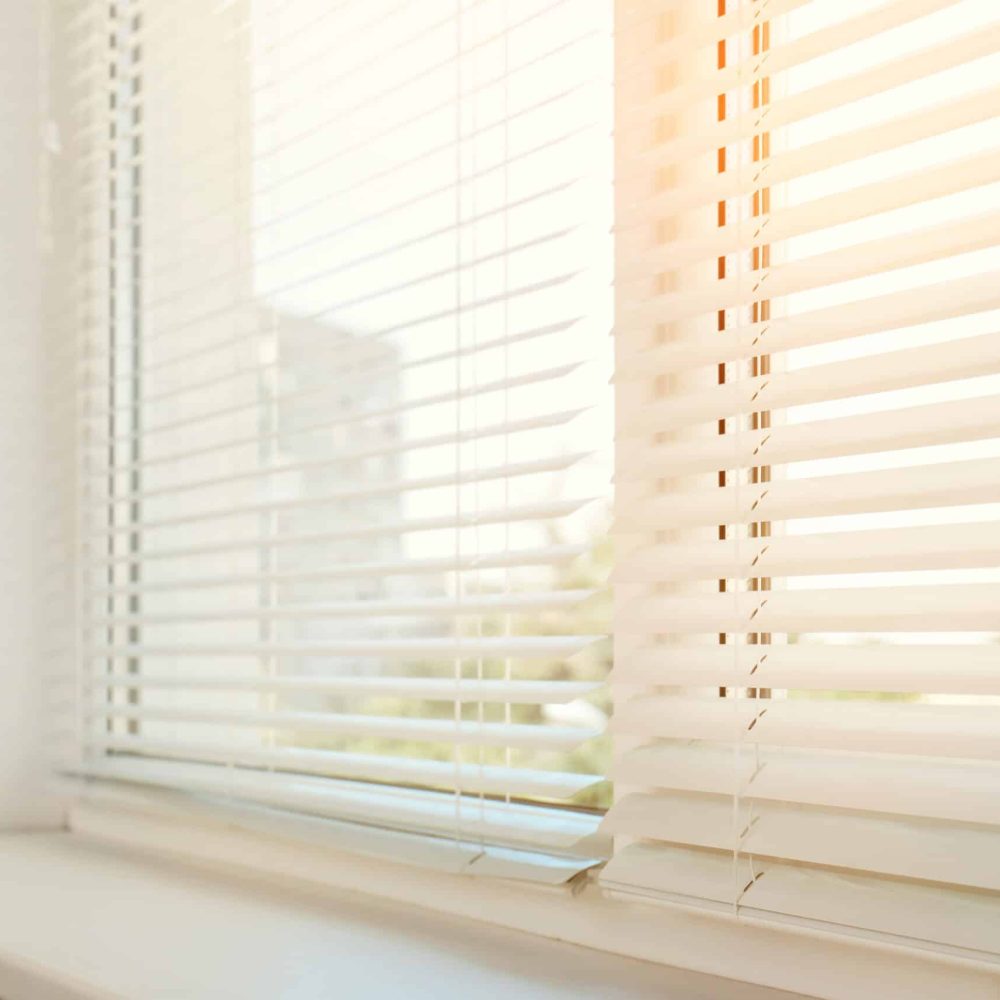 Beautiful view through window with blinds on sunny day, closeup